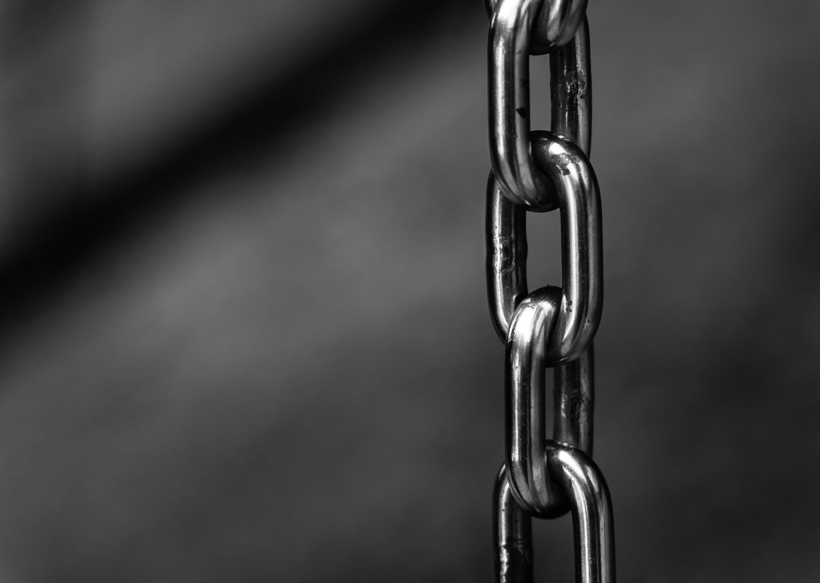 Close-up of a polished steel chain, its links interlocking against a blurred background