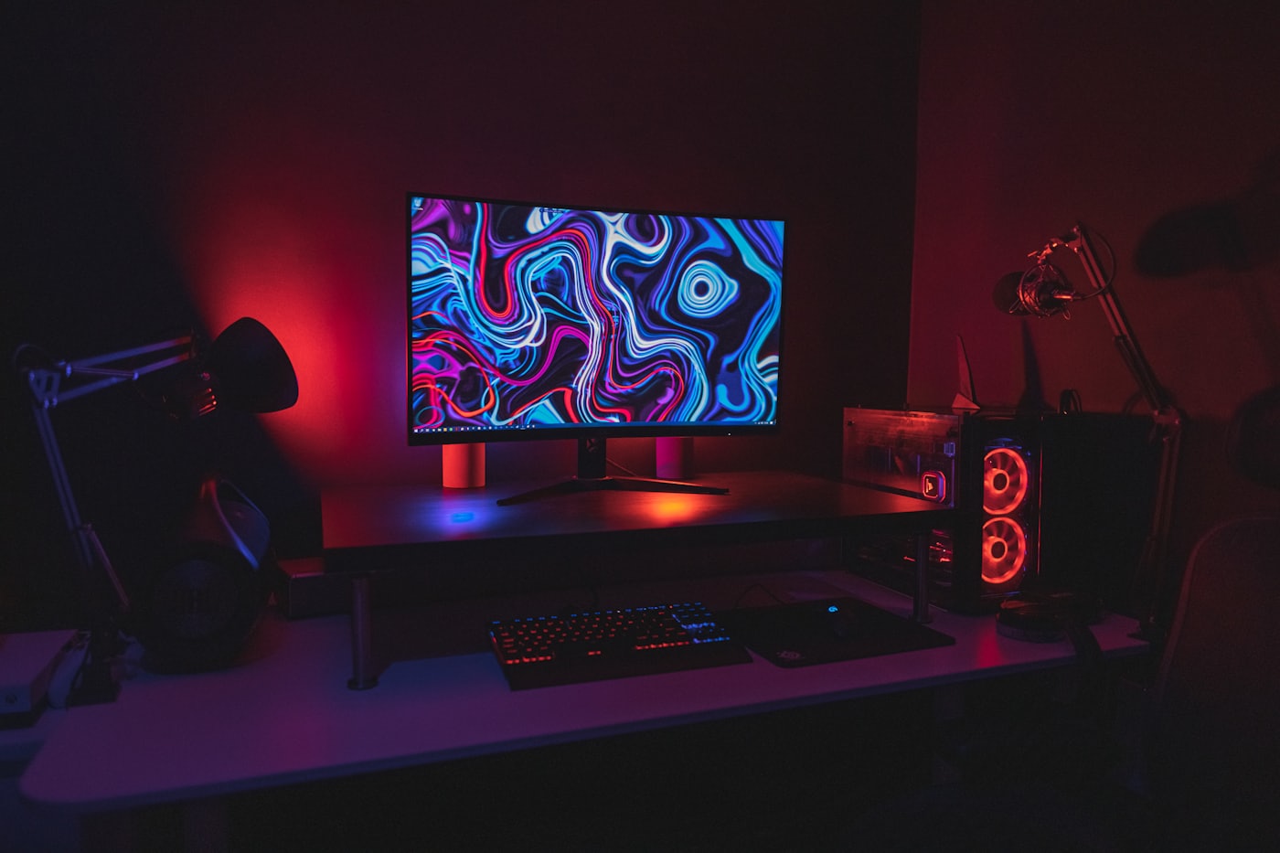 A dark gaming desk setup with RGB lighting
