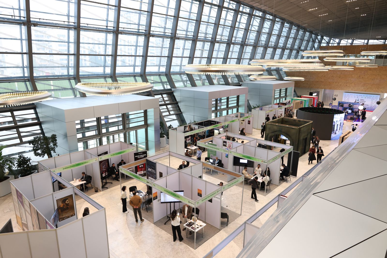 A busy trade show exhibition hall with attendees moving between booths