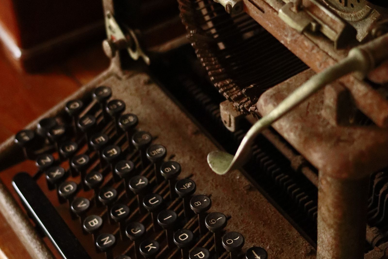 Close-up of an antique typewriter's keys and mechanism on a wooden desk